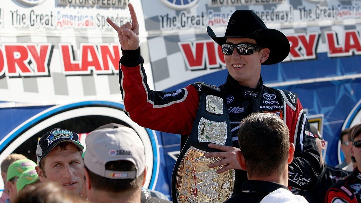 Kyle Busch holding WWE world championship belt celebrating victory at Texas Motor Speedway