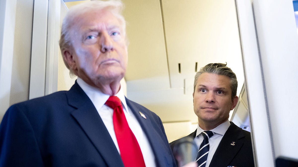 President Donald Trump speaking aboard Air Force One with War Secretary Pete Hegseth standing nearby