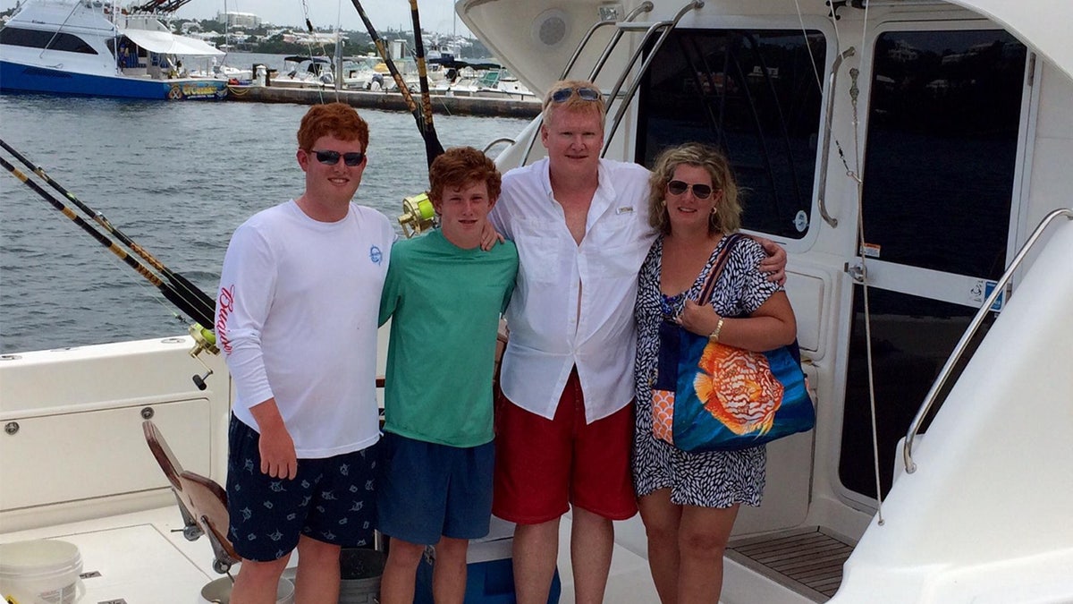 The Murdaugh family is shown together smiling on the deck of a fishing boat.
