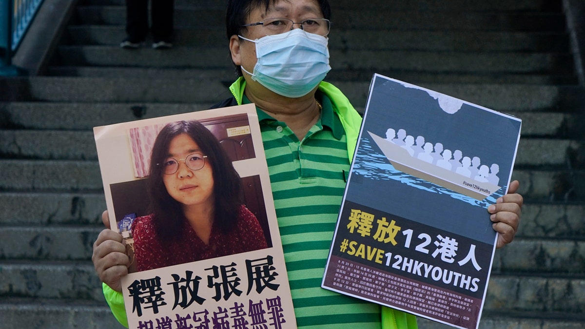 A pro-democracy activist holding placards with a picture of Chinese citizen journalist Zhang Zhan outside the Chinese central government's liaison office in Hong Kong