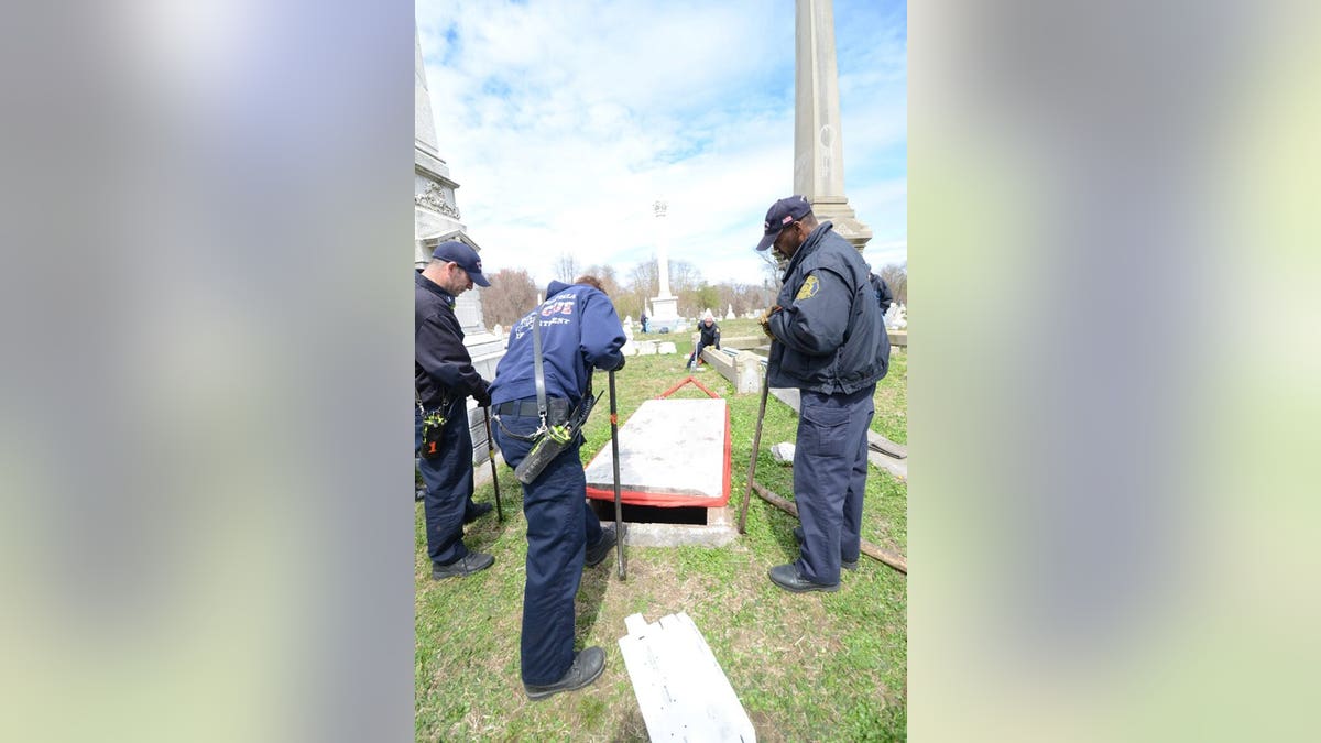 A close-up of police opening a crypt at Mt. Moriah Cemetery.