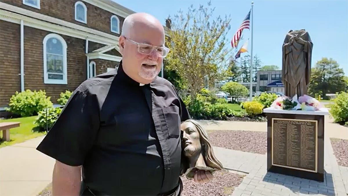 Pastor holding severed Jesus statue head outside church