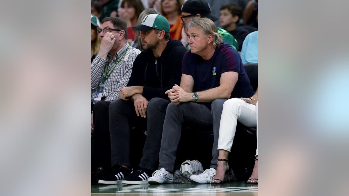 Aaron Rodgers and Wes Edens standing courtside at Fiserv Forum in Milwaukee