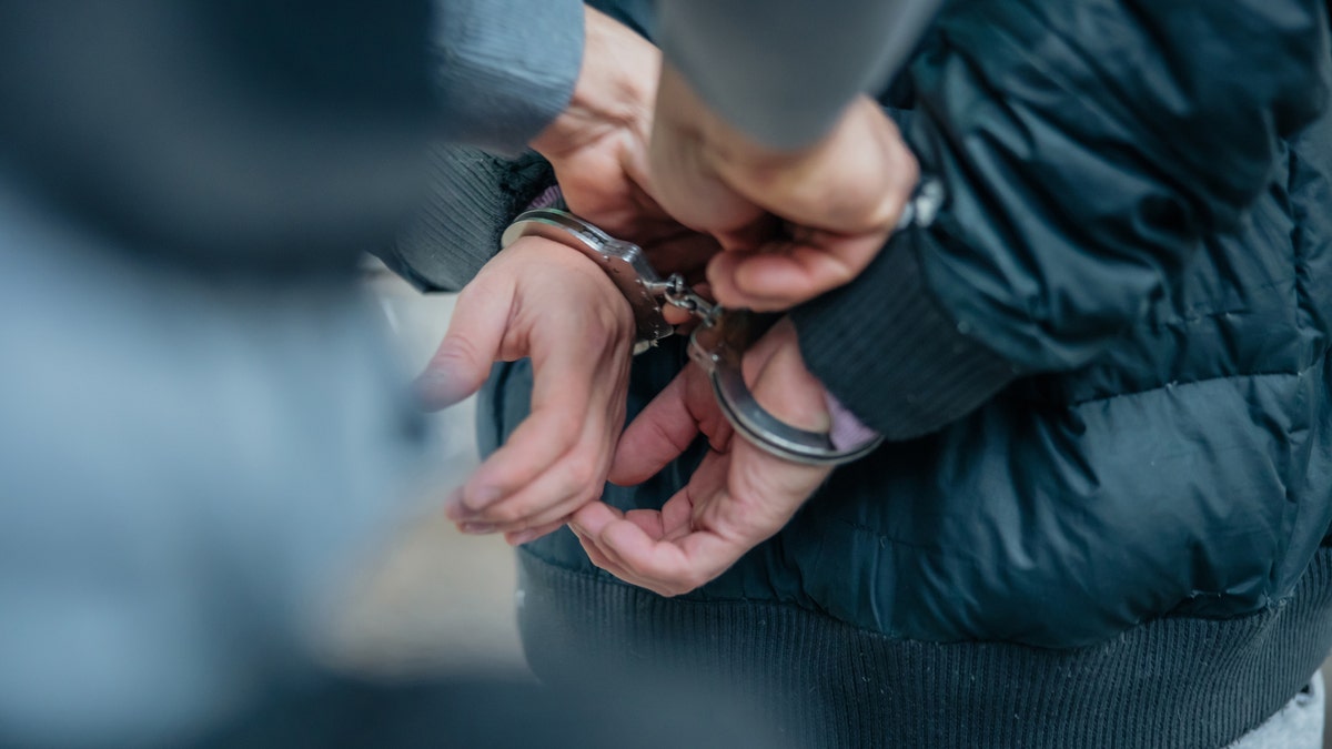 A criminal being handcuffed by law enforcement