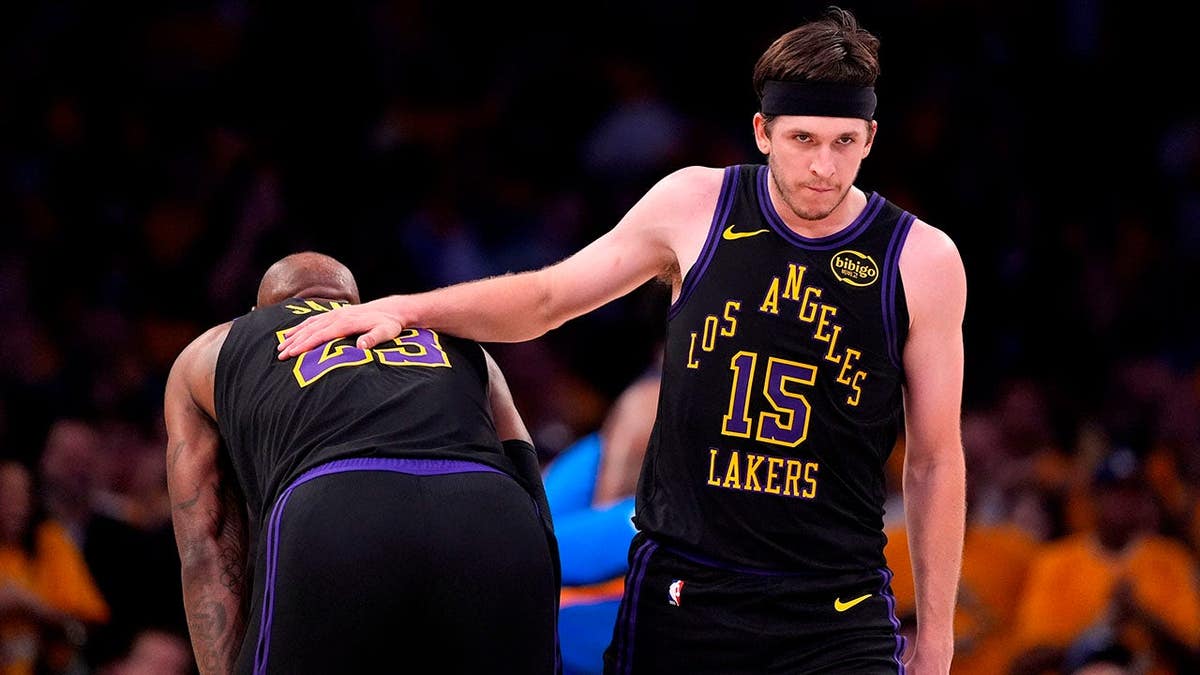 Los Angeles Lakers guard Austin Reaves pats forward LeBron James on the back during a game.