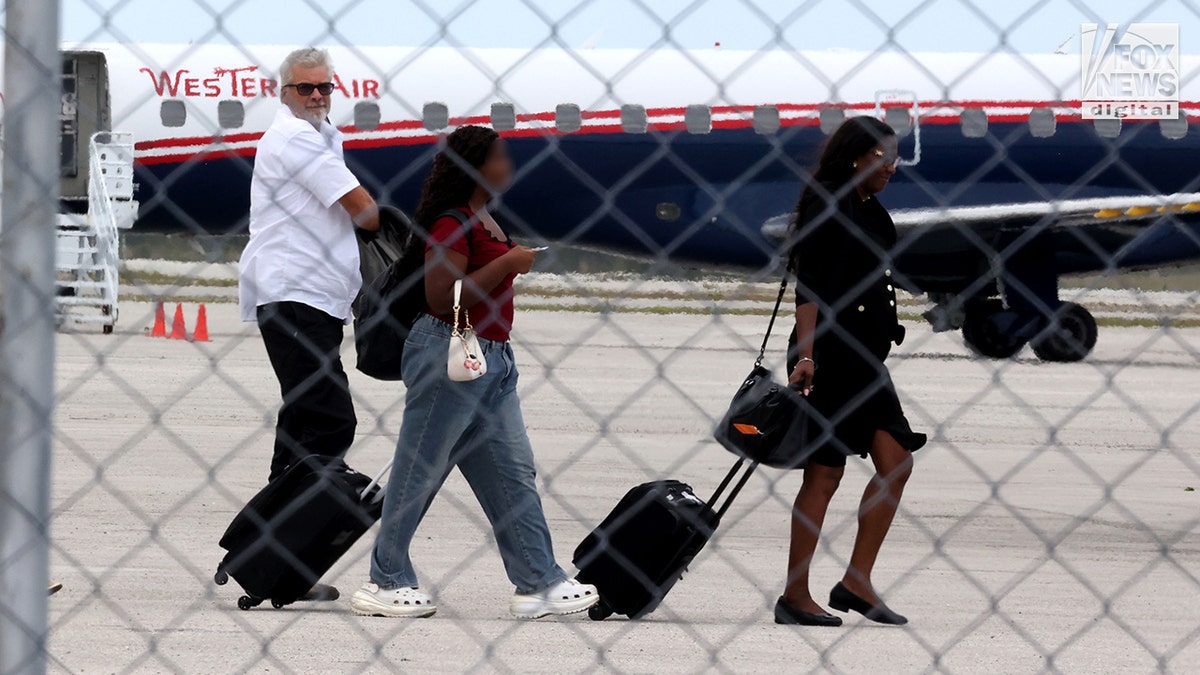 Brian Hooker boarding a plane at Grand Bahama Freeport Airport with lawyer Terell A. Butler