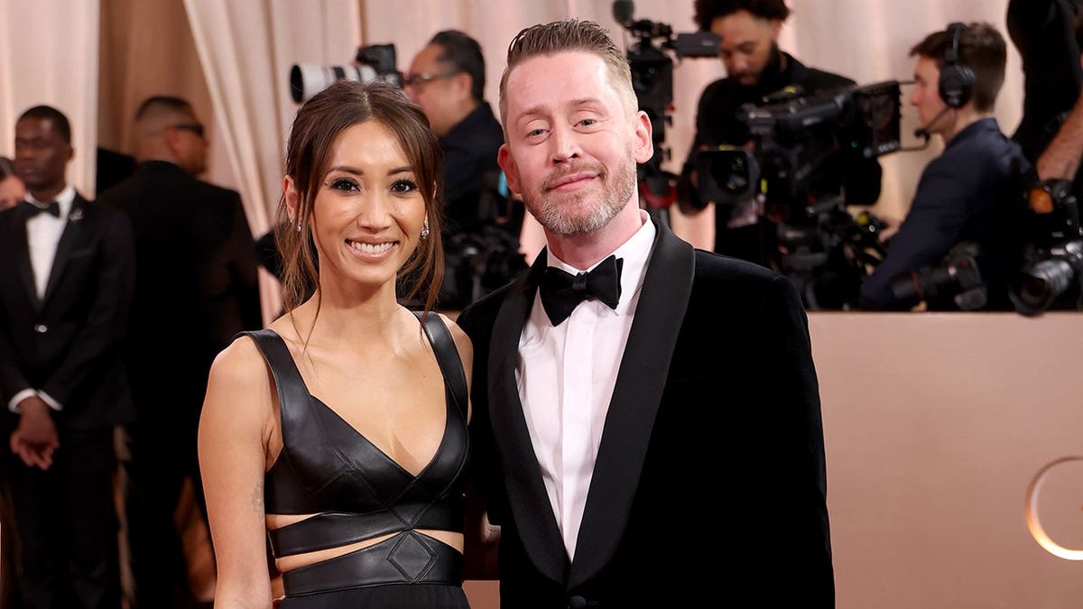 Brenda Song and Macaulay Culkin standing together at the Golden Globe Awards in Beverly Hills