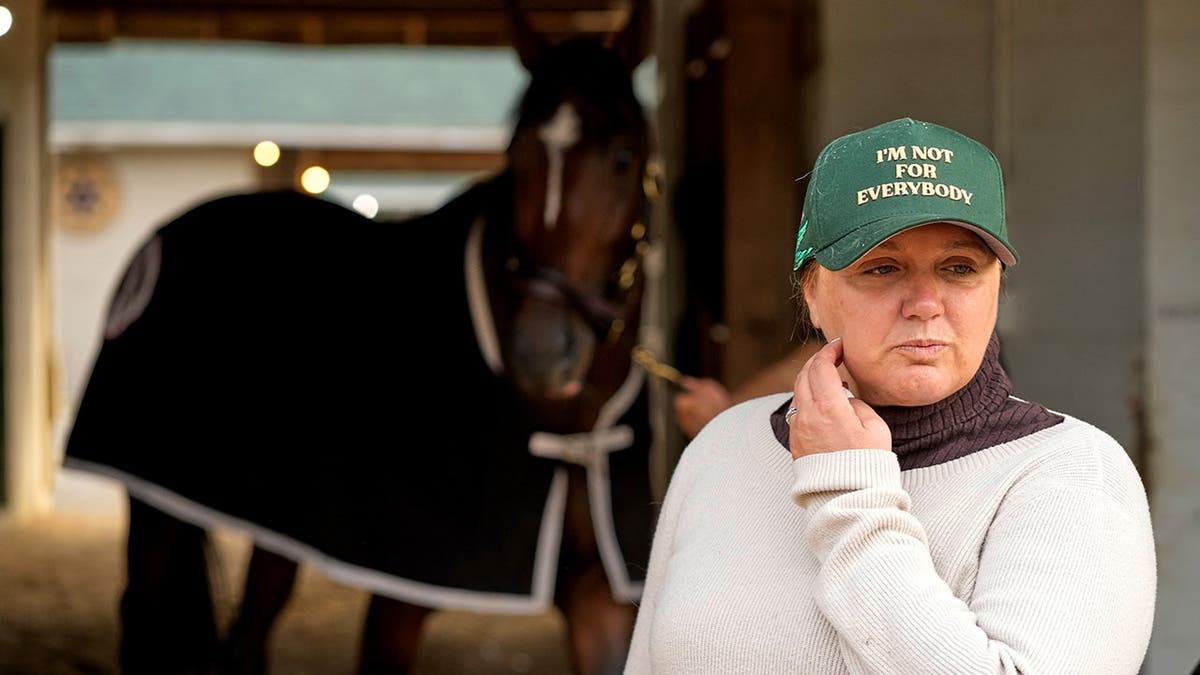 Trainer Cherie DeVaux standing outside a barn at Churchill Downs