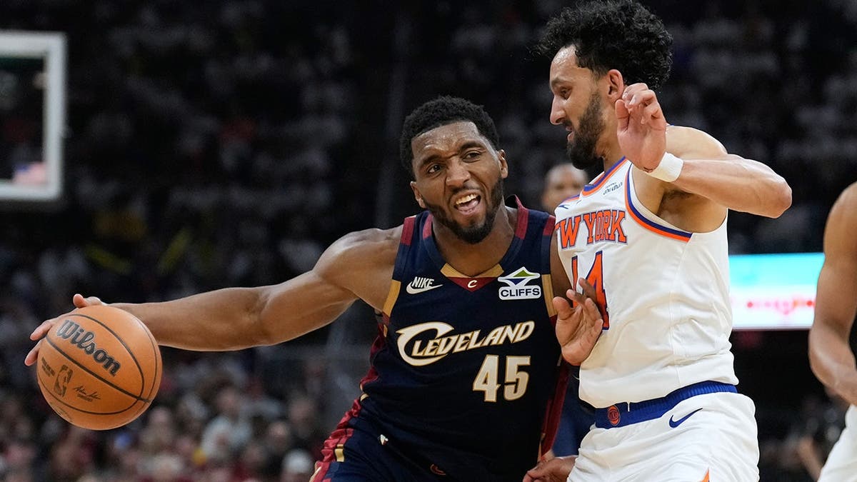 Donovan Mitchell controlling the basketball against Landry Shamet during a game.