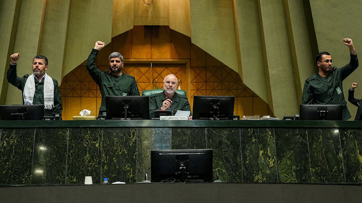 Iranian Parliament Speaker Mohammad-Bagher Ghalibaf looking on as parliament members chant in military uniforms