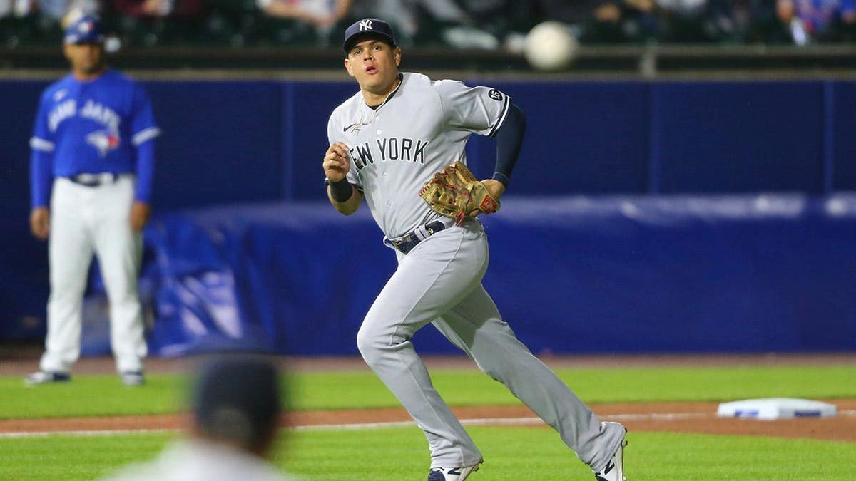 New York Yankees third baseman Gio Urshela throwing to first base during a baseball game.