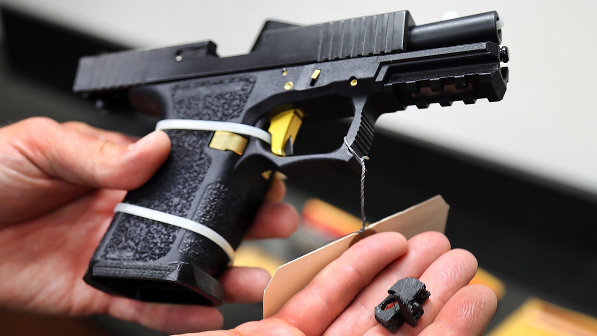 A Glock handgun with a machine gun conversion device attached.