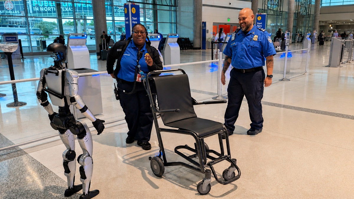 Humanoid robot and two TSA officers appear to dance near an airport security checkpoint.