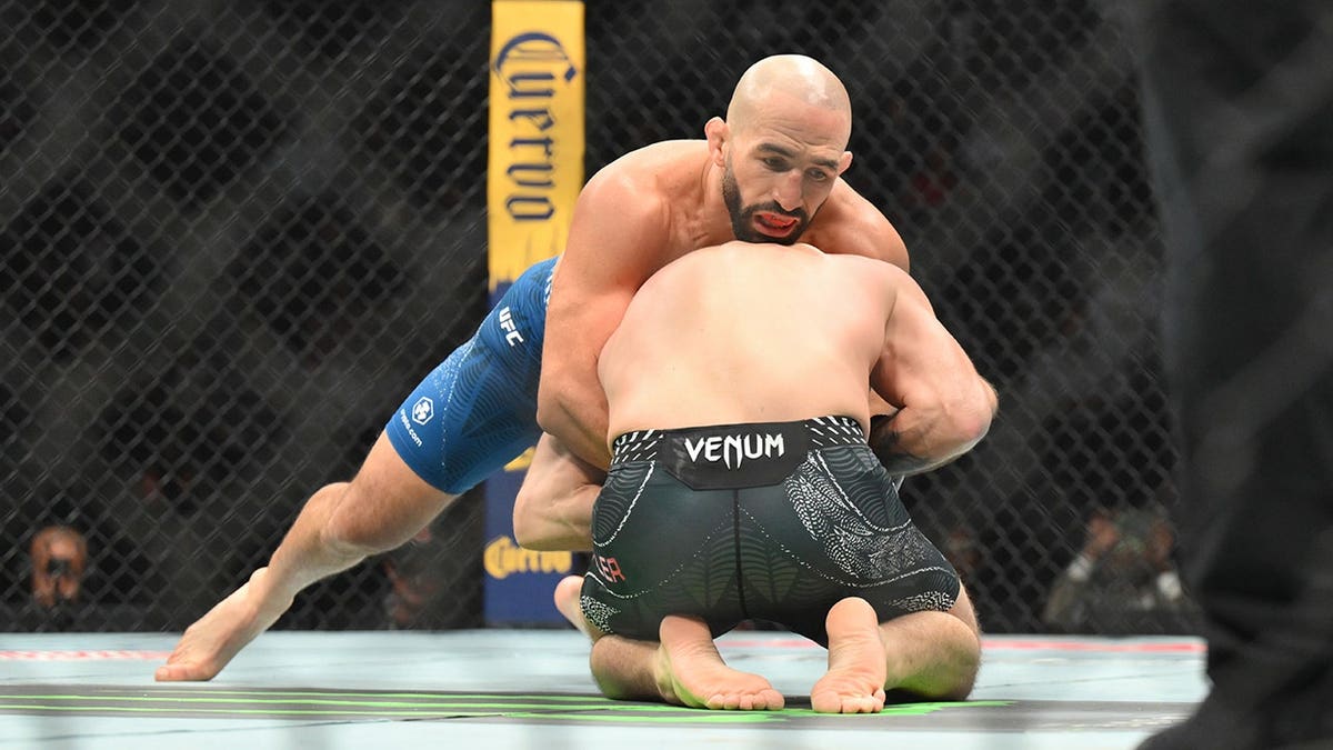 Jim Miller wearing red gloves fighting Jared Gordon wearing blue gloves in UFC match