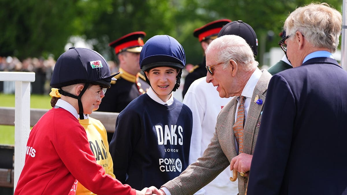 King Charles III greeting young riders at the Royal Windsor Horse Show in Windsor, Berkshire