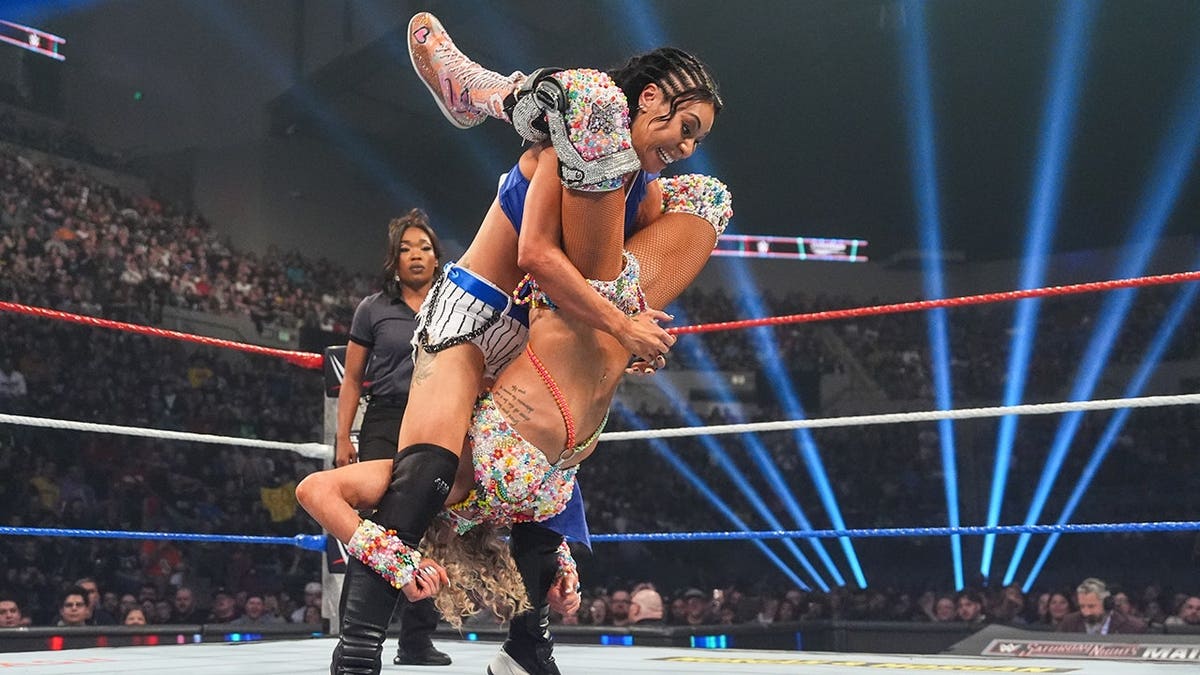 Michin performing a Styles Clash on Charlotte Flair in a wrestling ring