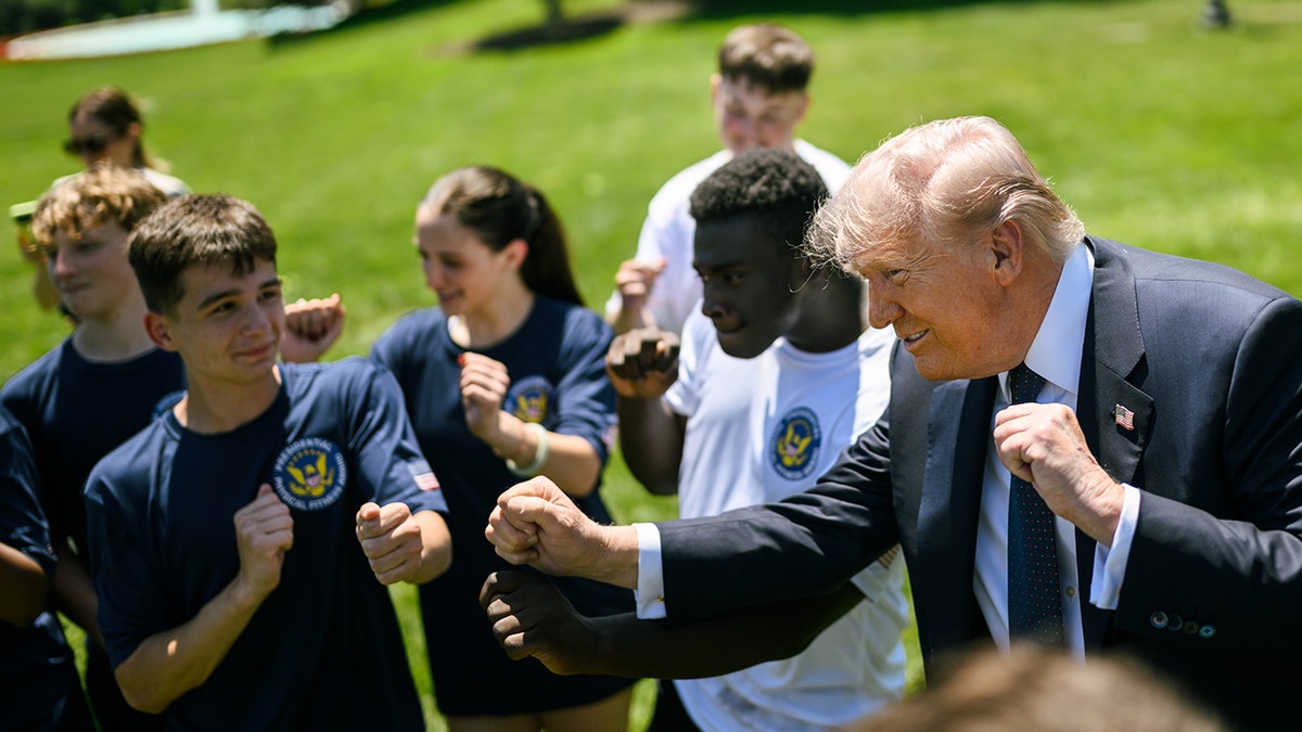 President Trump does YMCA dance move with students.