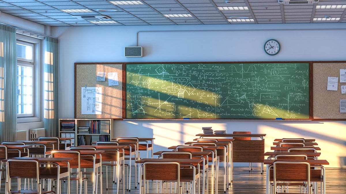 Empty school classroom with wooden desks and chairs