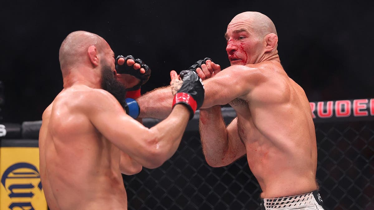 Sean Strickland punches Khamzat Chimaev during UFC middleweight championship fight