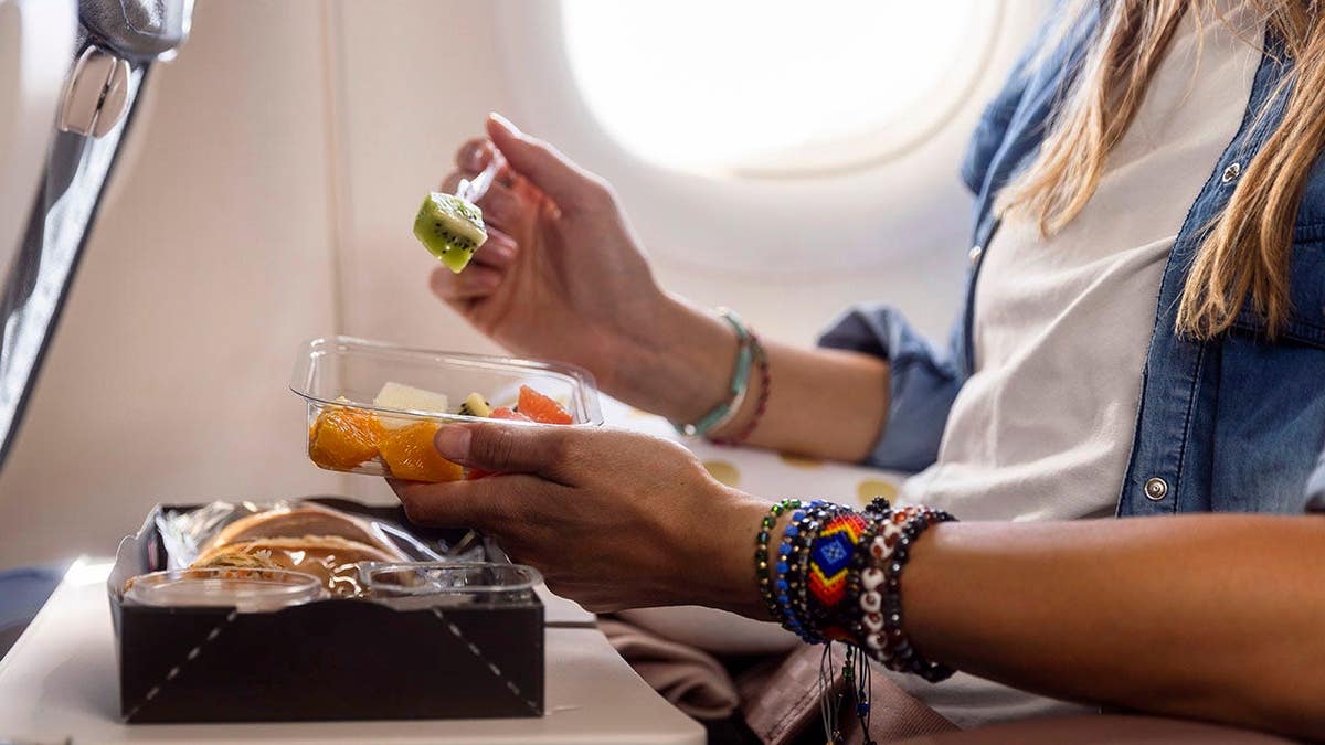 Woman enjoying a gourmet meal while seated on a flight