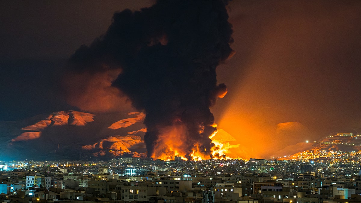 Smoke and flames rising from an oil depot after airstrikes in Tehran