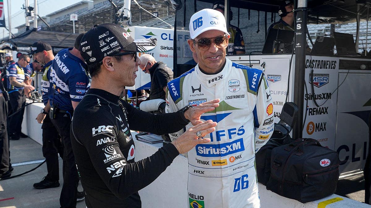Takuma Sato and Helio Castroneves talking during practice at Indianapolis Motor Speedway