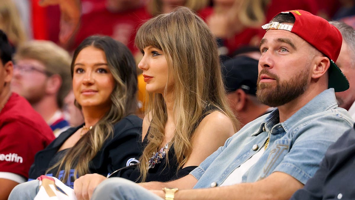 Singer Taylor Swift and Travis Kelce seated at Rocket Arena during NBA Eastern Conference Finals game.