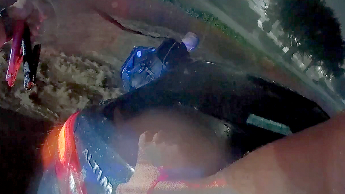 Bodycam image shows Texas police officer standing in rushing floodwaters during rescue.