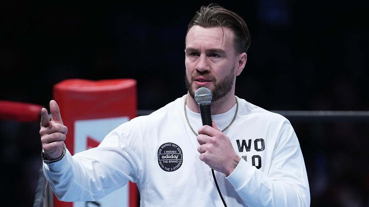 Will Ospreay speaking at a New Japan Pro-Wrestling event in Tokyo gymnasium