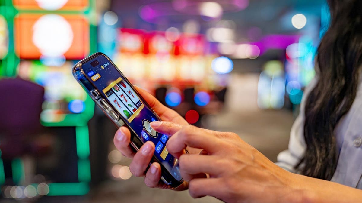 A woman plays a slot machine game on her cellphone.