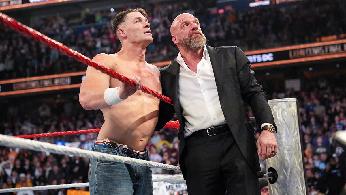 John Cena and Triple H looking at the screen during Saturday Night's Main Event