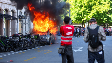 Anti-G7 protest turns violent as demonstrators torch Tesla and smash UN office windows