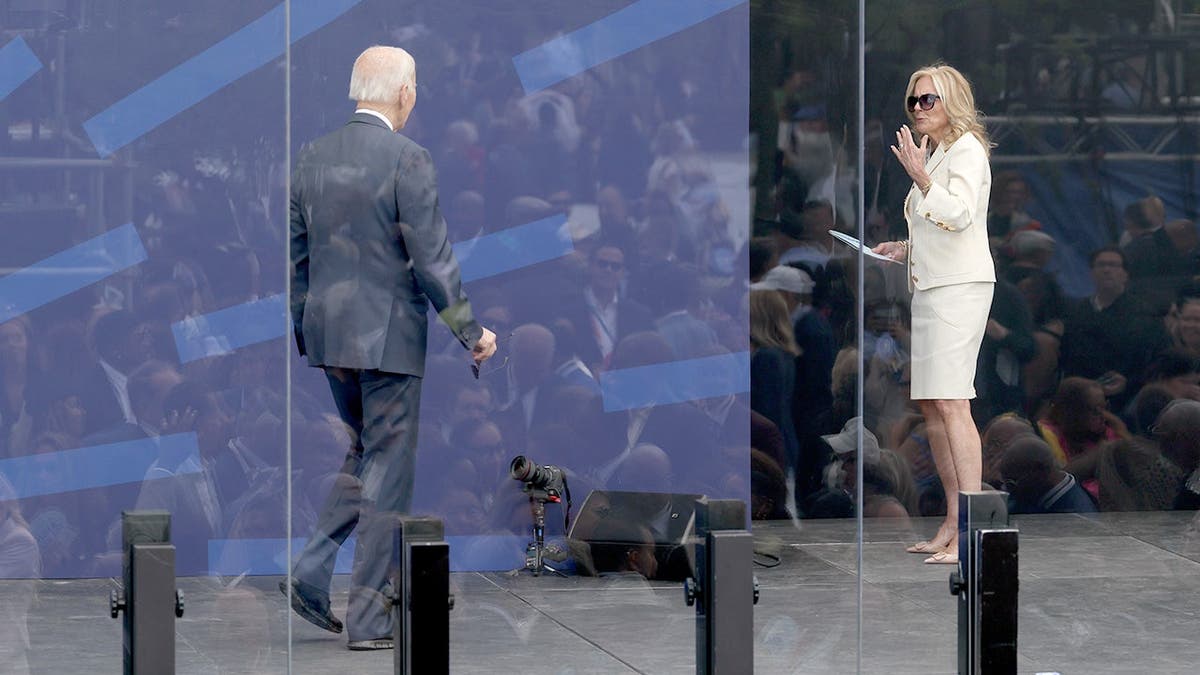 Joe Biden and Jill Biden standing on a stage during an outdoor event.