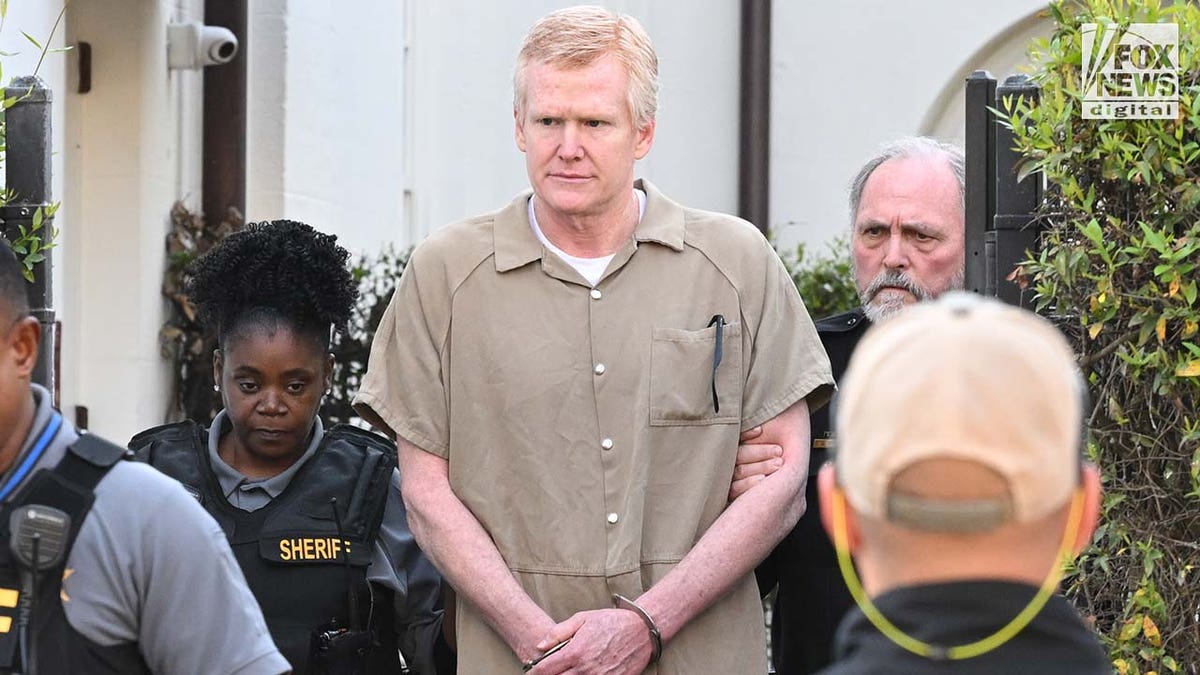 Alex Murdaugh in tan prison jumpsuit being led out of Colleton County courthouse