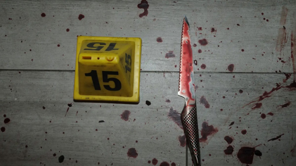 Blood-stained serrated kitchen knife on a white surface