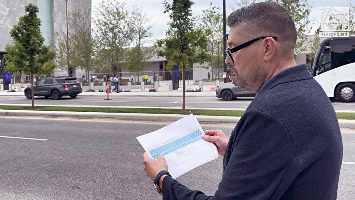 Mike Owen holding documents outside the Obama Presidential Center.