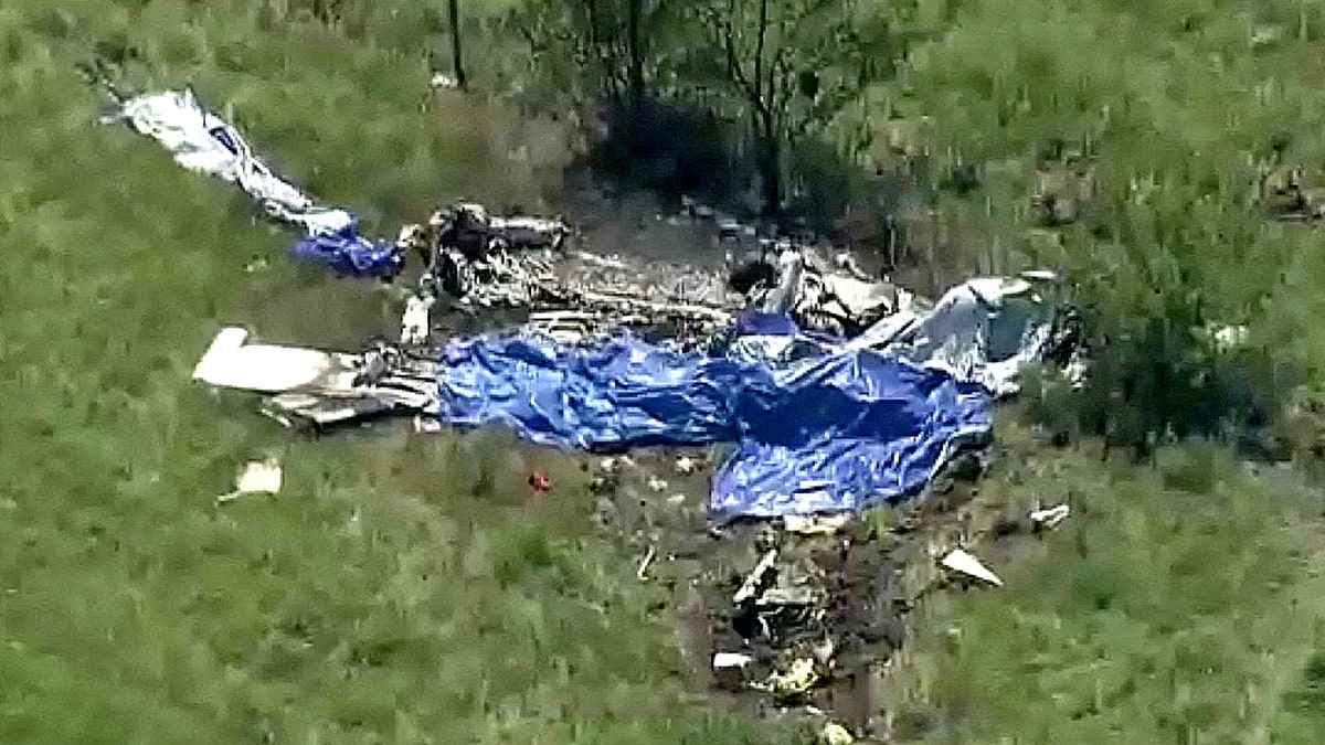 Wreckage of a crashed plane lying in a field next to Butler Memorial Airport