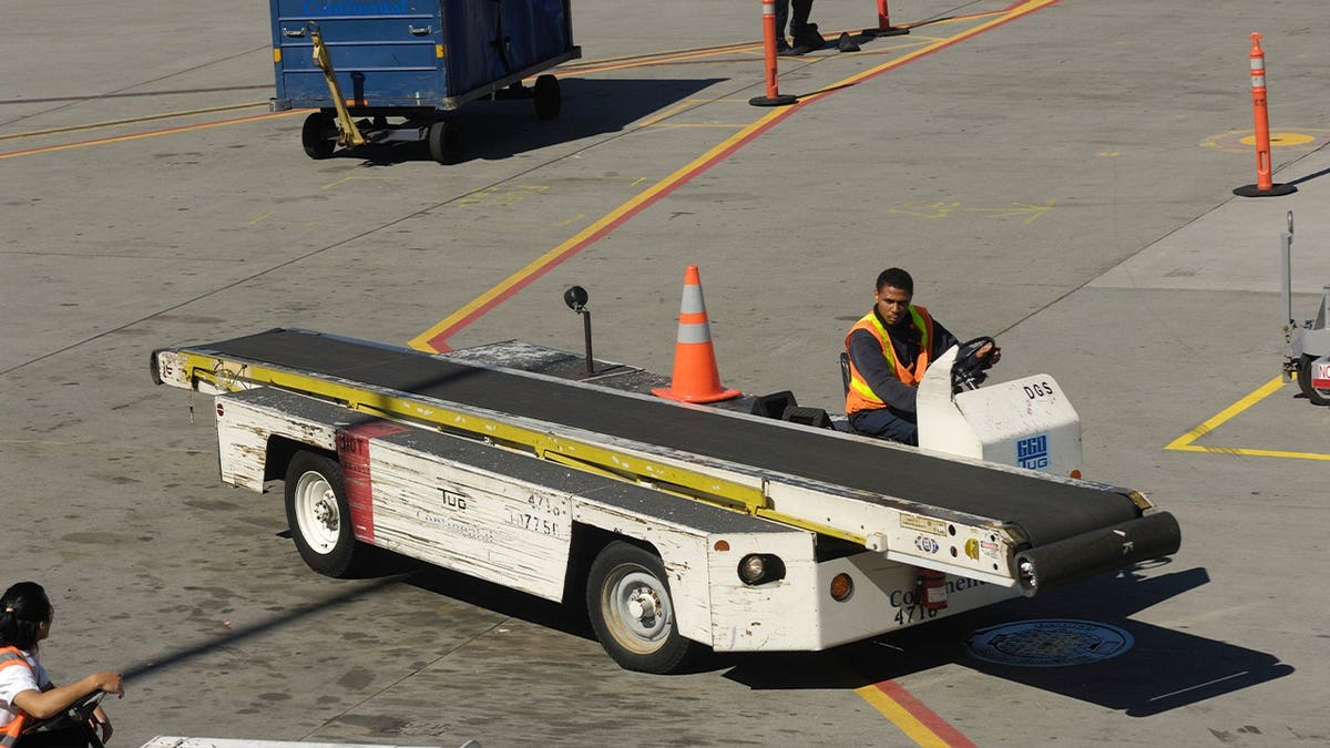 worker drives ground airport vehicle