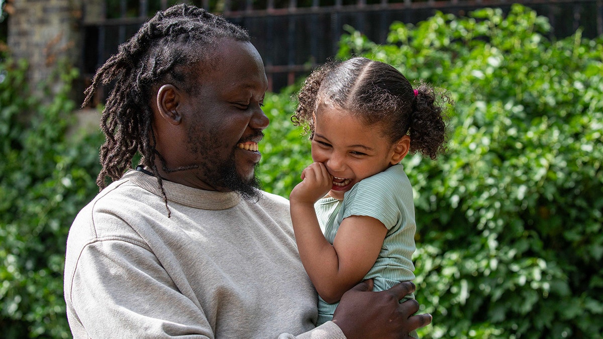 Anthony Kalejaiye holds his daughter, Amelia, as they share a laugh.