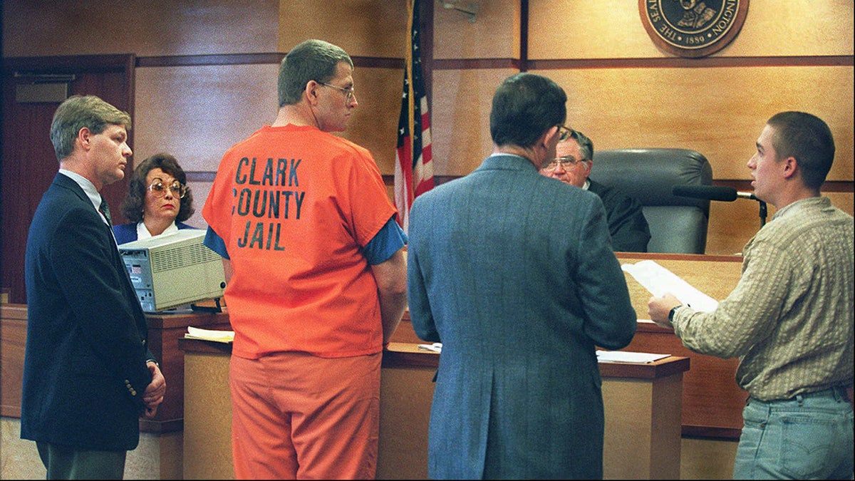 Keith Jesperson wearing orange jail garb standing in court with Don Findlay addressing him