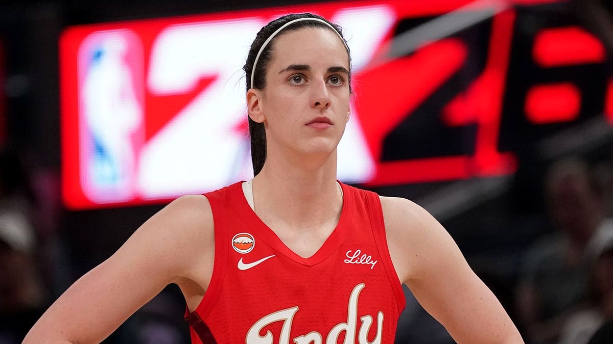 Indiana Fever guard Caitlin Clark standing on basketball court waiting for play to resume