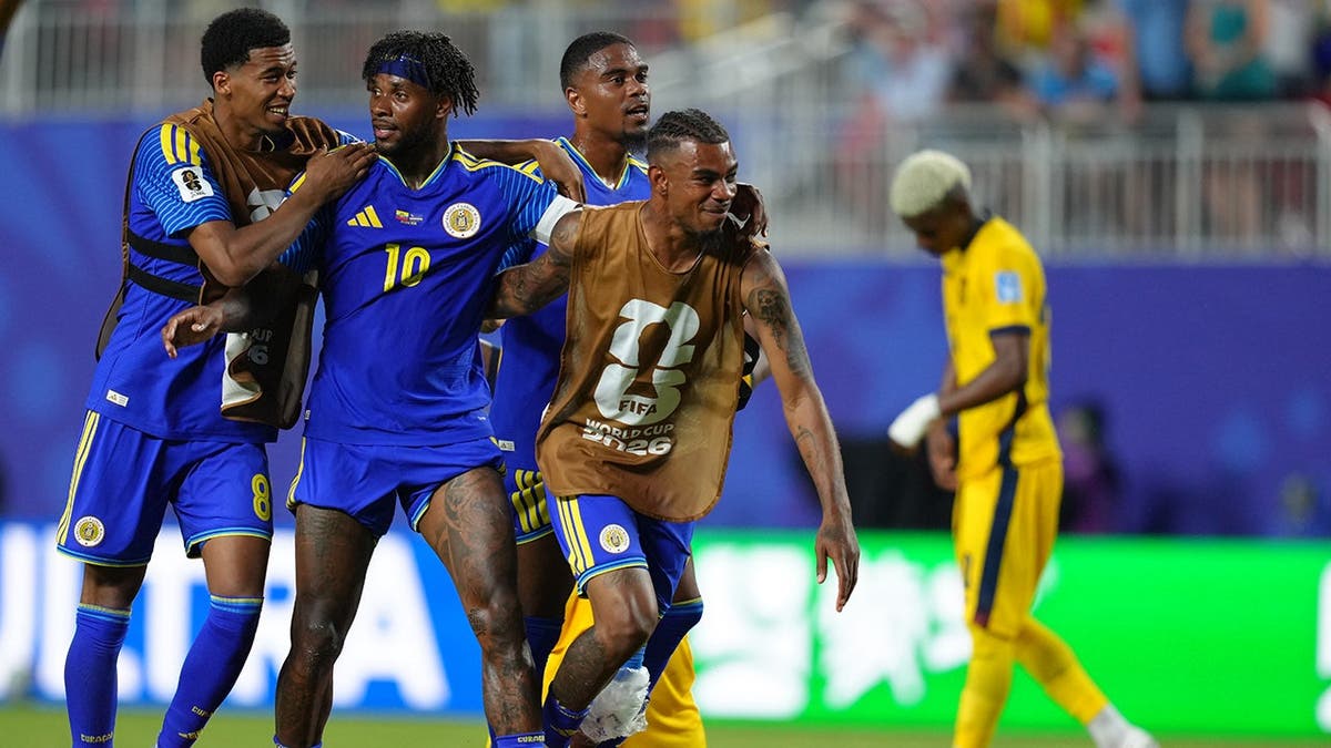 Leandro Bacuna celebrating with teammates on soccer field in Kansas City