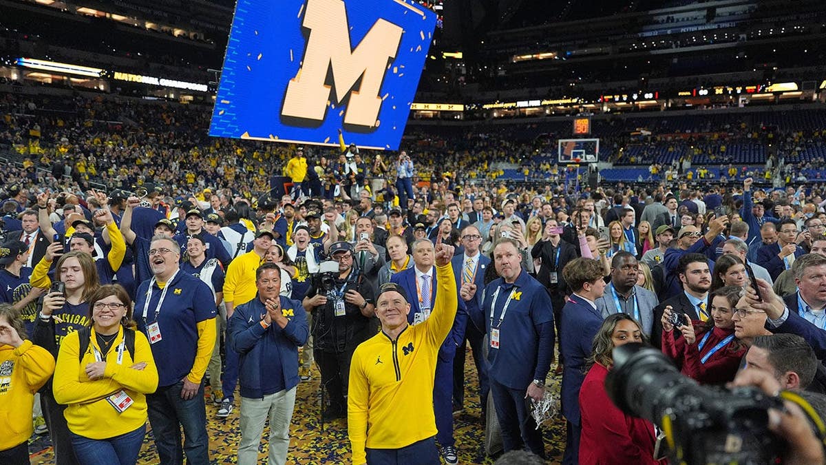 Michigan head coach Dusty May celebrating on the basketball court.