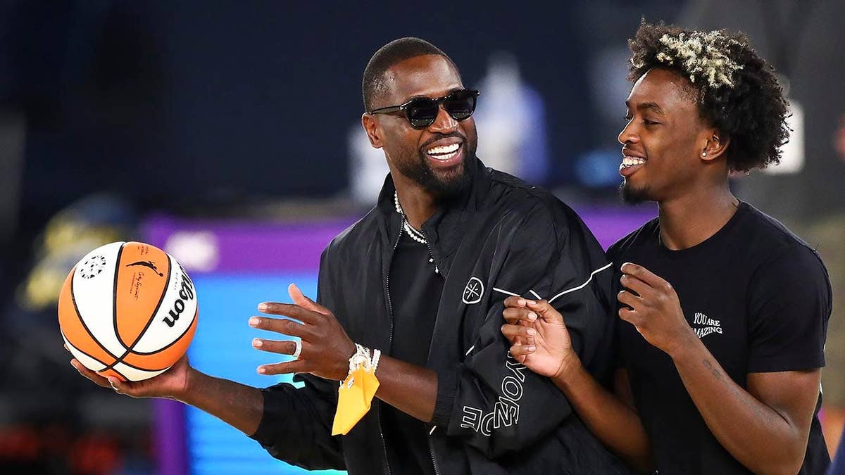 Former NBA player Dwyane Wade and his son Zaire Wade standing on a basketball court