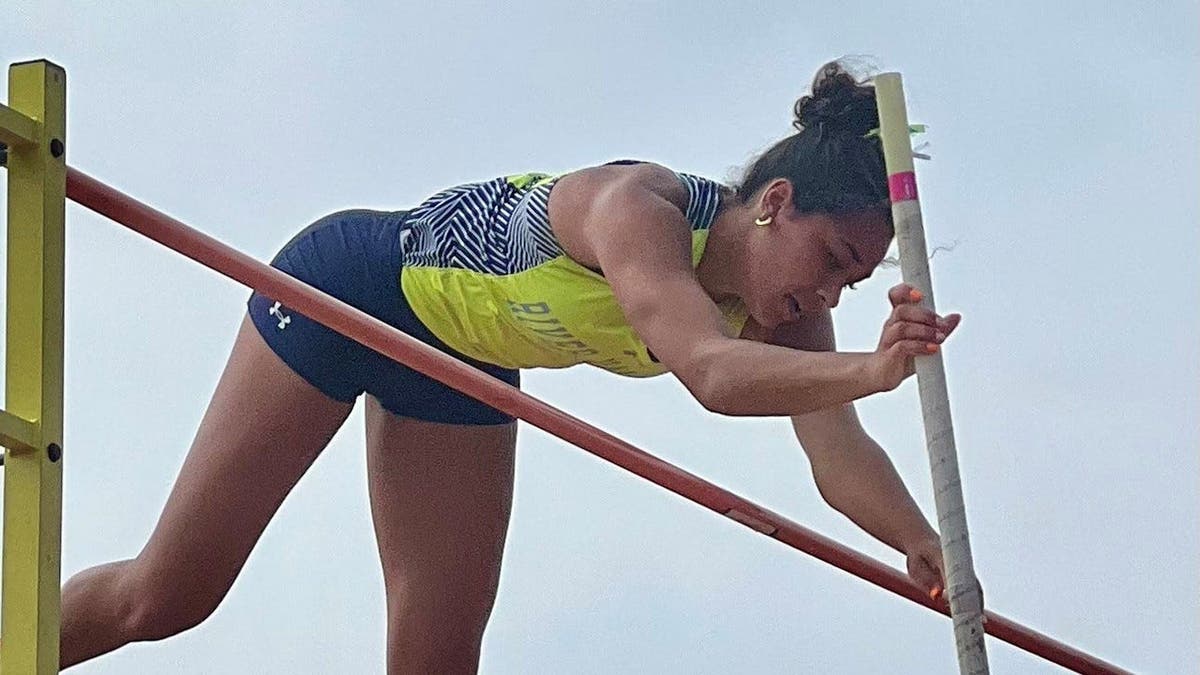 Eva Moran vaulting over the pole vault bar at Jesse Owens Memorial Stadium
