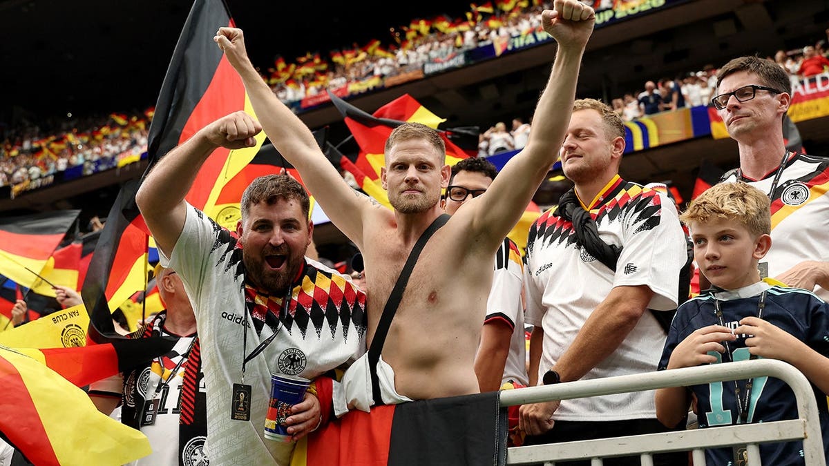 Germany fans seated in the stands at a stadium.