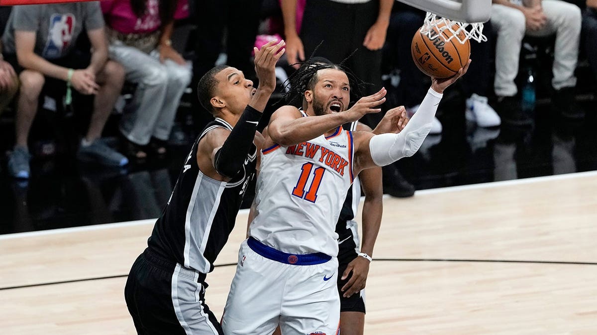 New York Knicks guard Jalen Brunson drives past San Antonio Spurs forward Victor Wembanyama during NBA Finals game.