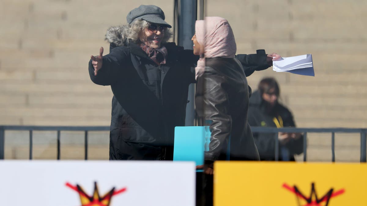 Jane Fonda and Congresswoman Ilhan Omar standing onstage at a rally in St. Paul, Minnesota