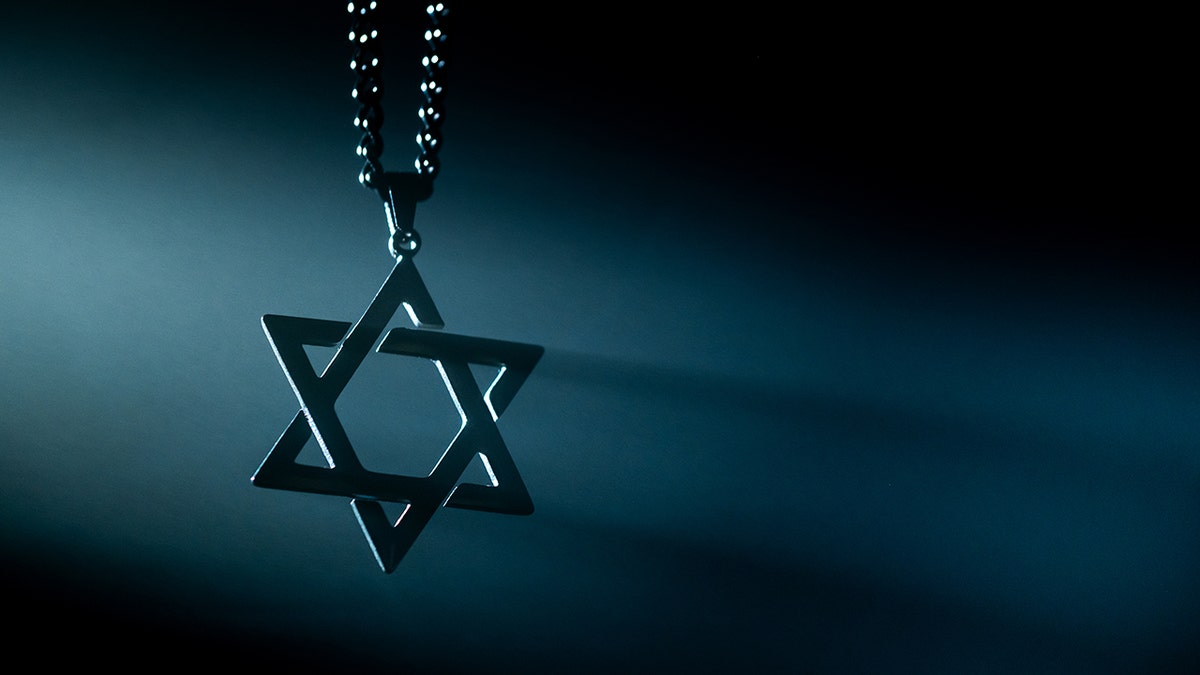 Star of David necklace over dark background