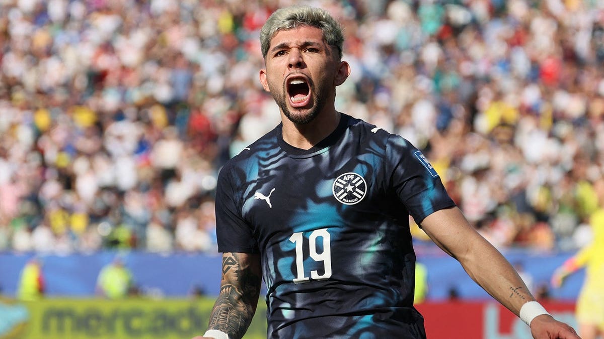 Paraguay's midfielder Julio Enciso celebrating after scoring a goal on the field.